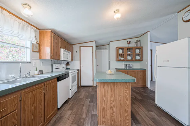 a kitchen with a table chairs refrigerator and microwave