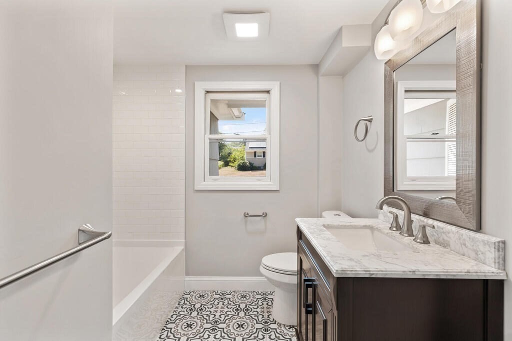 8 Smith Road Randolph, MA 02368 - Photo 12 of 31 a bathroom with a granite countertop sink a toilet and a mirror