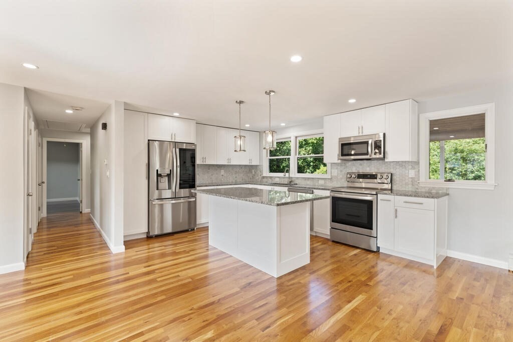8 Smith Road Randolph, MA 02368 - Photo 6 of 31 a kitchen with stainless steel appliances white cabinets a sink a stove a refrigerator and a microwave