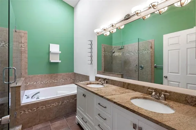a bathroom with a granite countertop bathtub sink and mirror