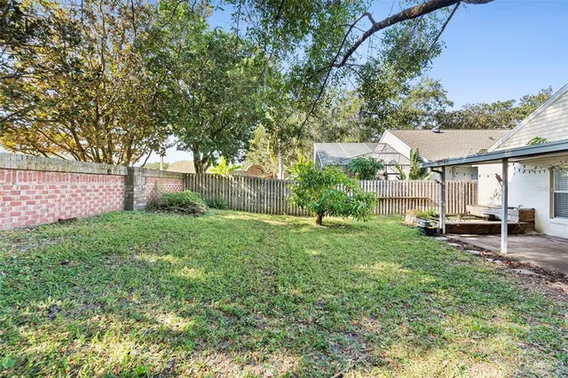 a view of a backyard with table and chairs and a large tree