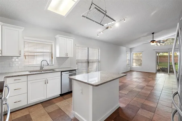 a large white kitchen with a large window