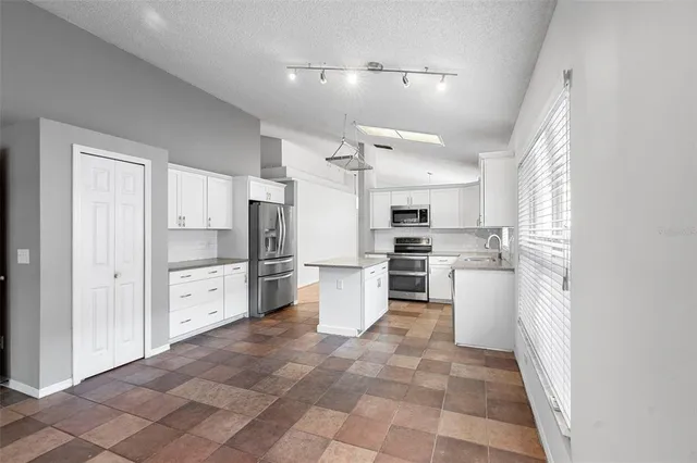 a kitchen with refrigerator and cabinets