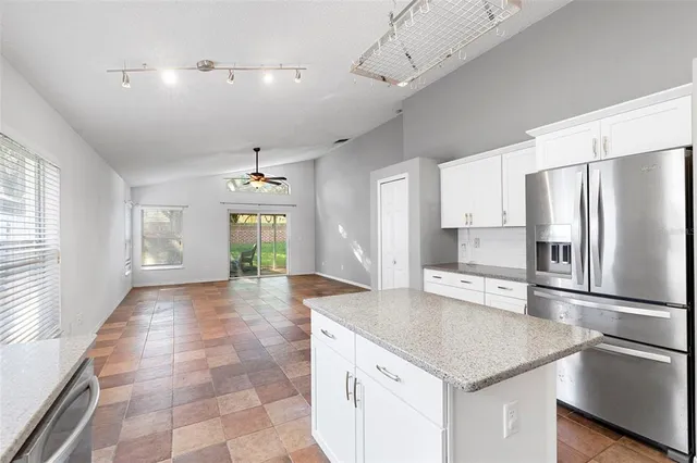 a kitchen with a center island and stainless steel appliances