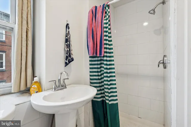 a bathroom with a sink a mirror and a shower