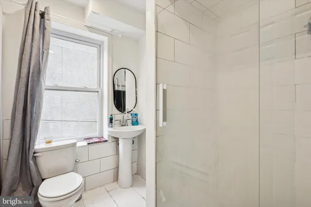 a bathroom with a toilet a sink and a window
