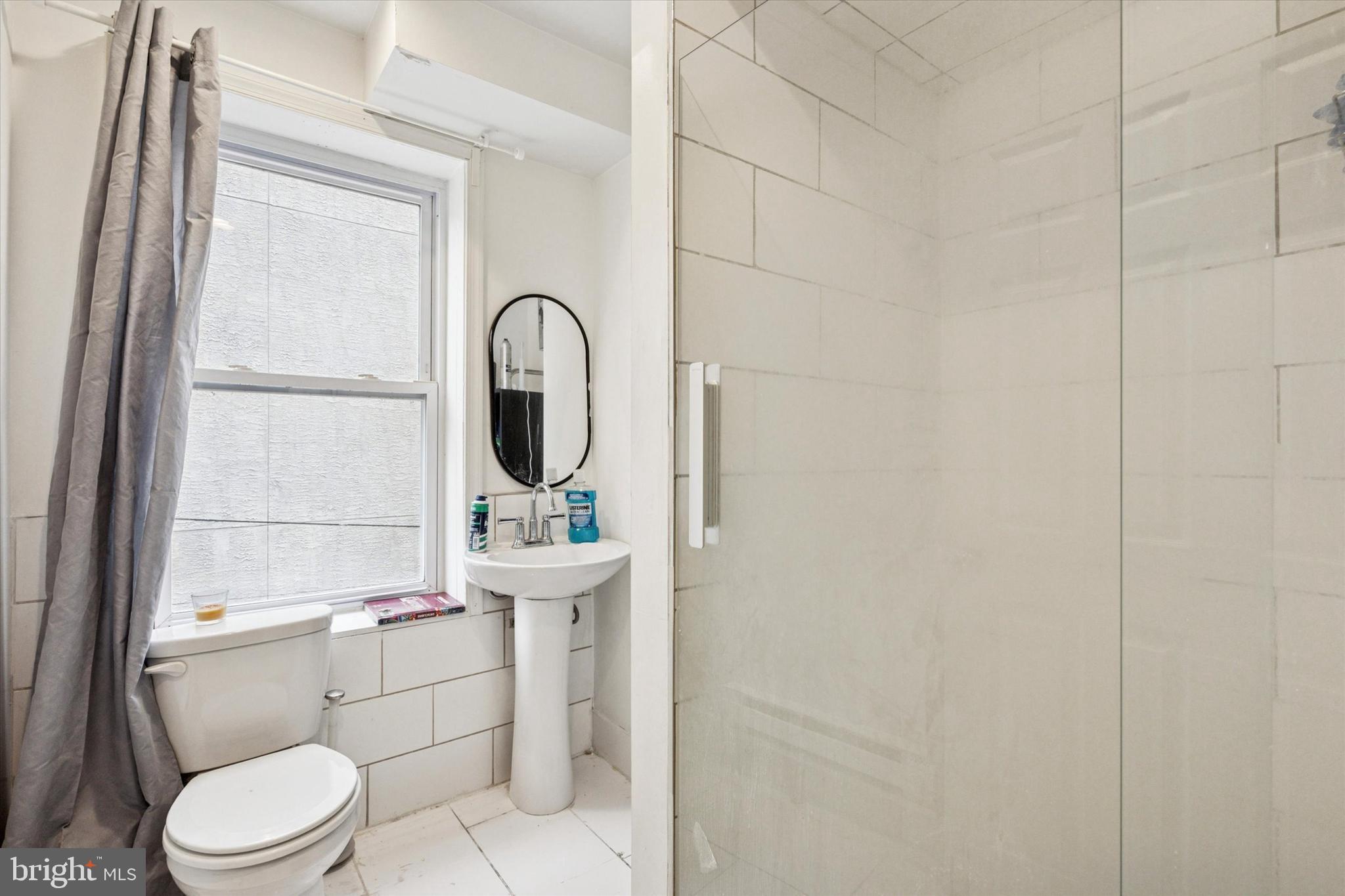 517 North 35th Street Philadelphia, PA 19104 - Photo 20 of 24 a bathroom with a toilet a sink and a window