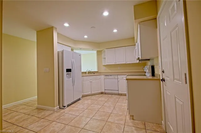 a kitchen with a refrigerator a sink and cabinets