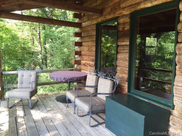 833 Hidden Valley Road Clyde, NC 28721 - Photo 8 of 14 a view of a patio with table and chairs potted plants with floor to ceiling window