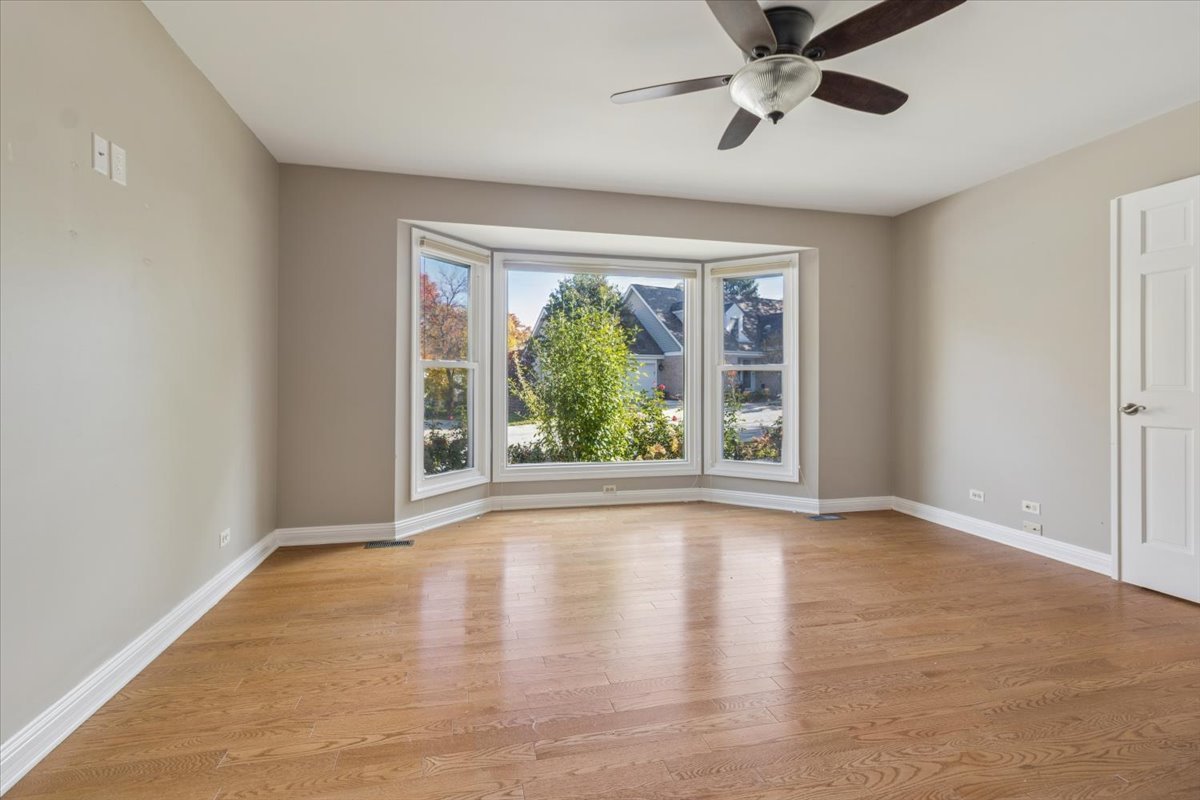 417 River Bluff Circle Naperville, IL 60540 - Photo 6 of 20 a view of an empty room with wooden floor and a window