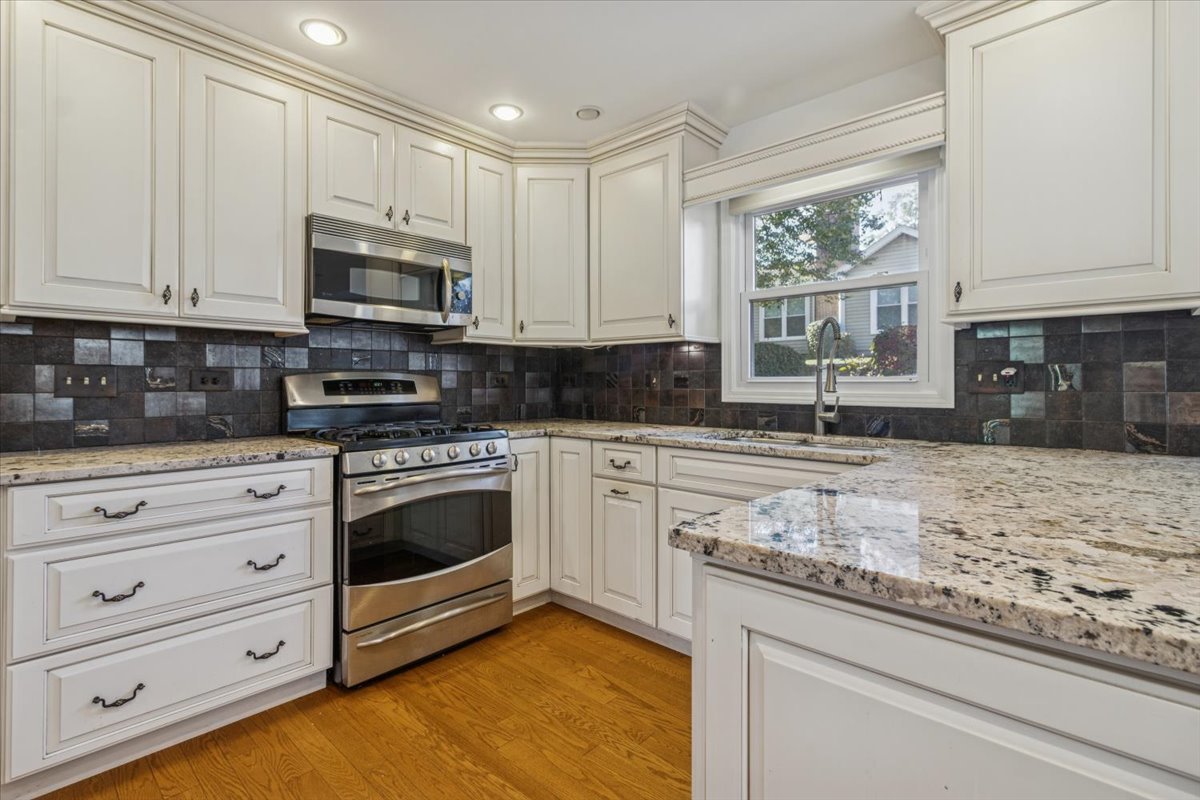 417 River Bluff Circle Naperville, IL 60540 - Photo 7 of 20 a kitchen with granite countertop white cabinets stainless steel appliances and a window