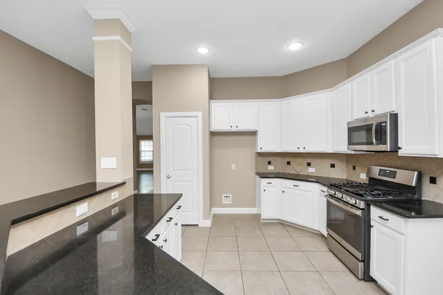 a kitchen with stainless steel appliances a refrigerator a stove top oven a sink and cabinets