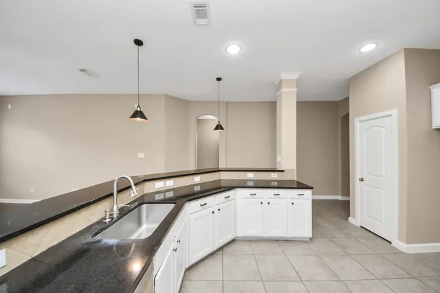 a view of a kitchen with a sink and chandelier