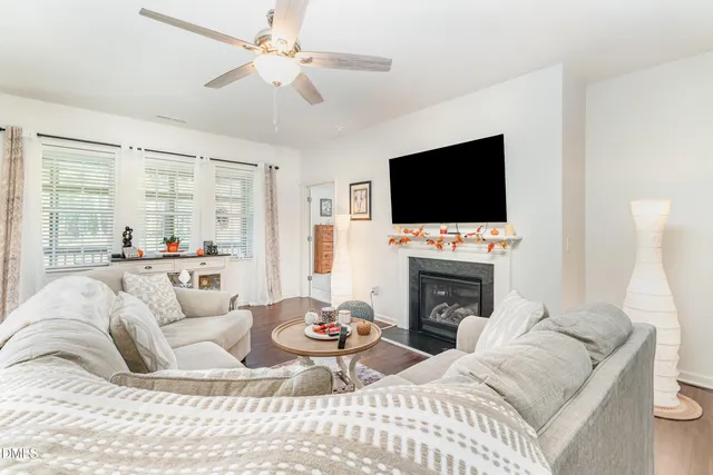 a living room with furniture a fireplace and a flat screen tv