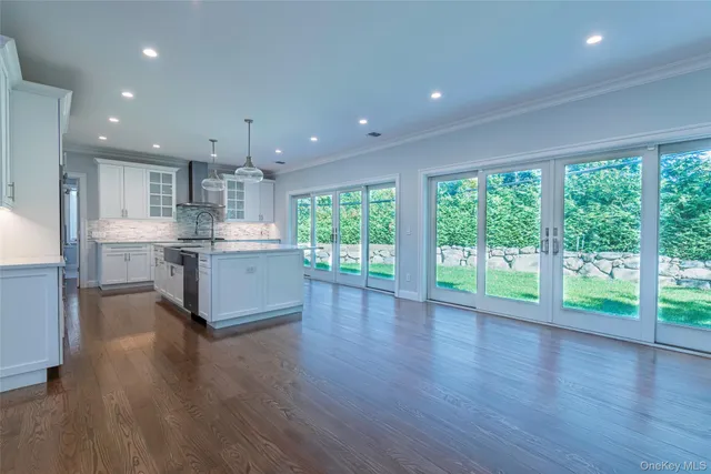 a open kitchen with kitchen island wooden floors and white cabinets