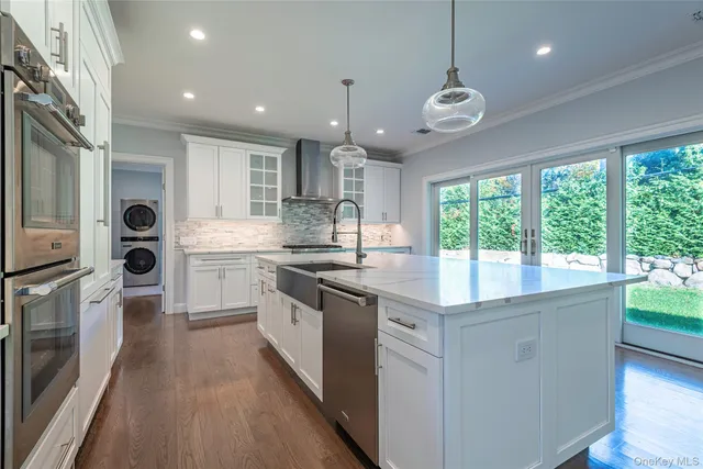 a kitchen with stainless steel appliances granite countertop a sink a stove and a refrigerator