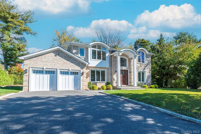 a front view of a house with garden and trees