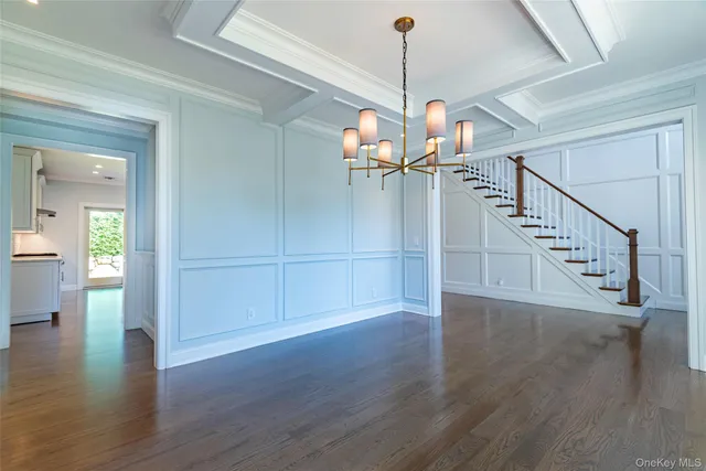 a view of a room with wooden floor staircase and a kitchen