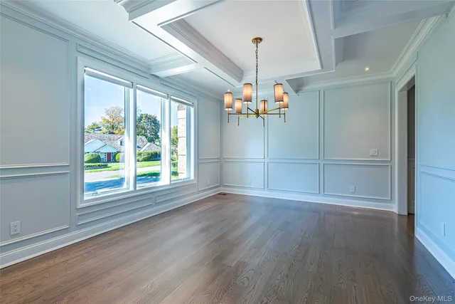 a view of an empty room with wooden floor fridge and a window