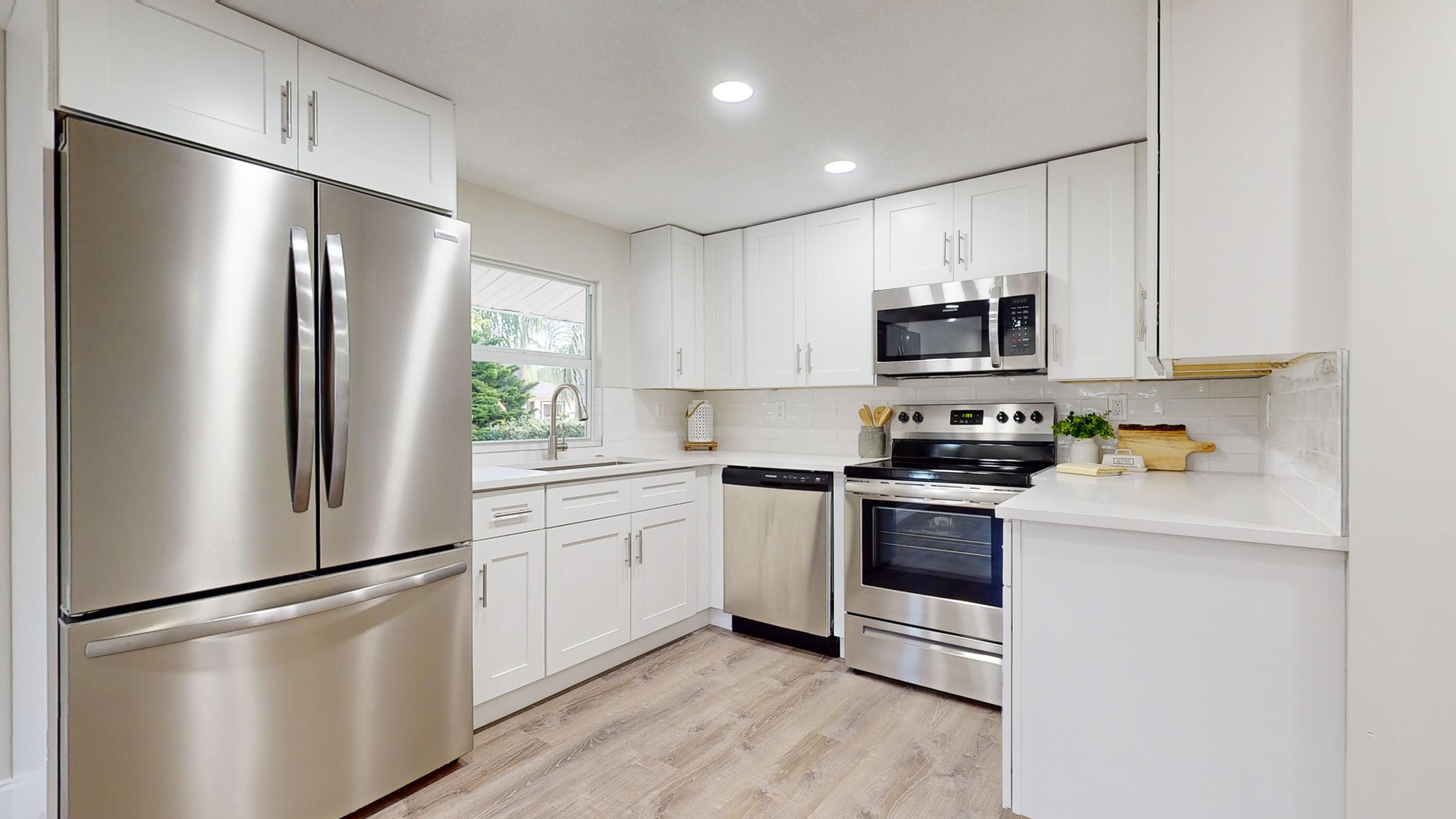 a kitchen with stainless steel appliances a refrigerator sink and microwave