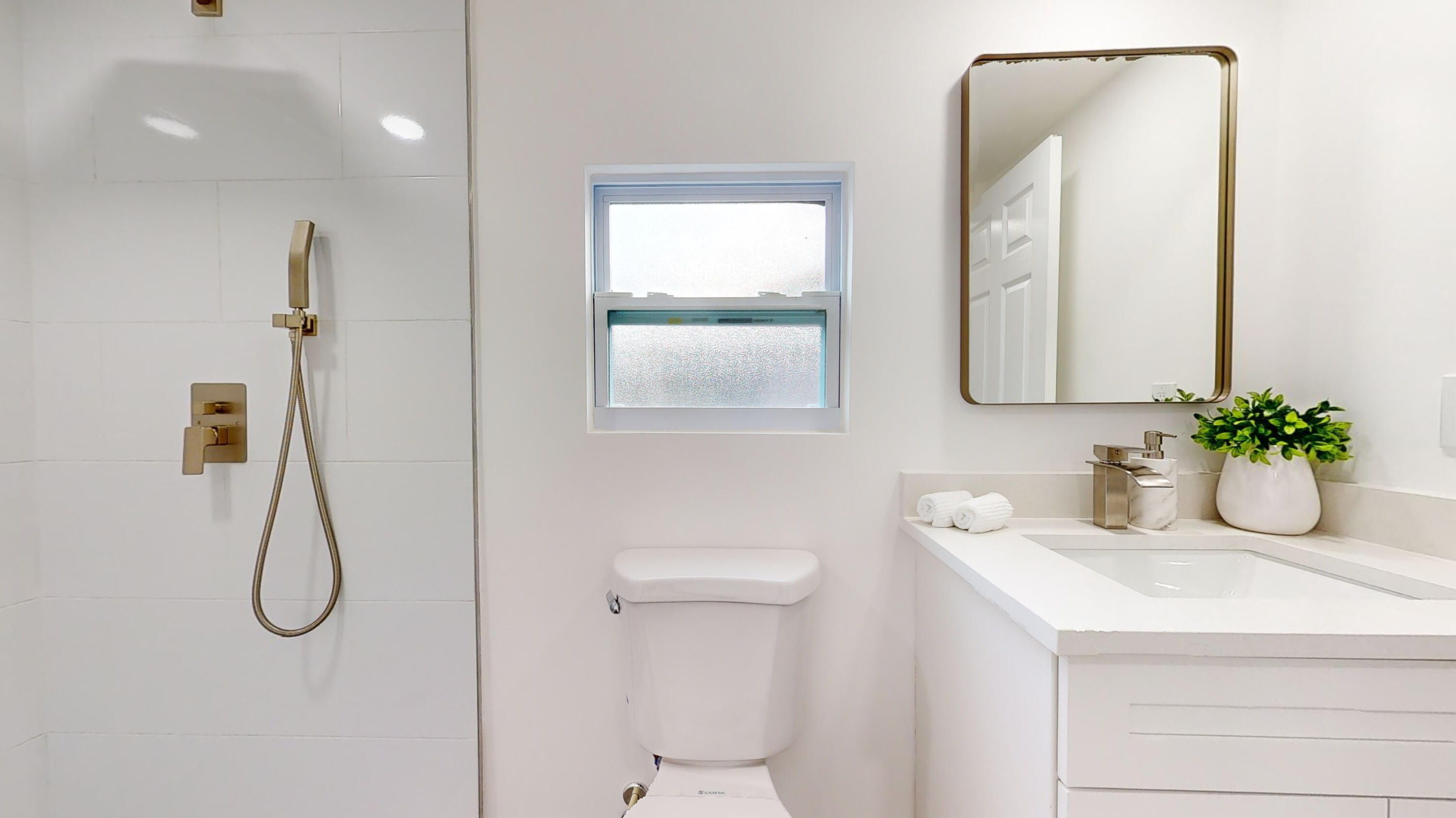 6674 4th Street Jupiter, FL 33458 - Photo 13 of 21 a bathroom with a sink a light fixture and a window