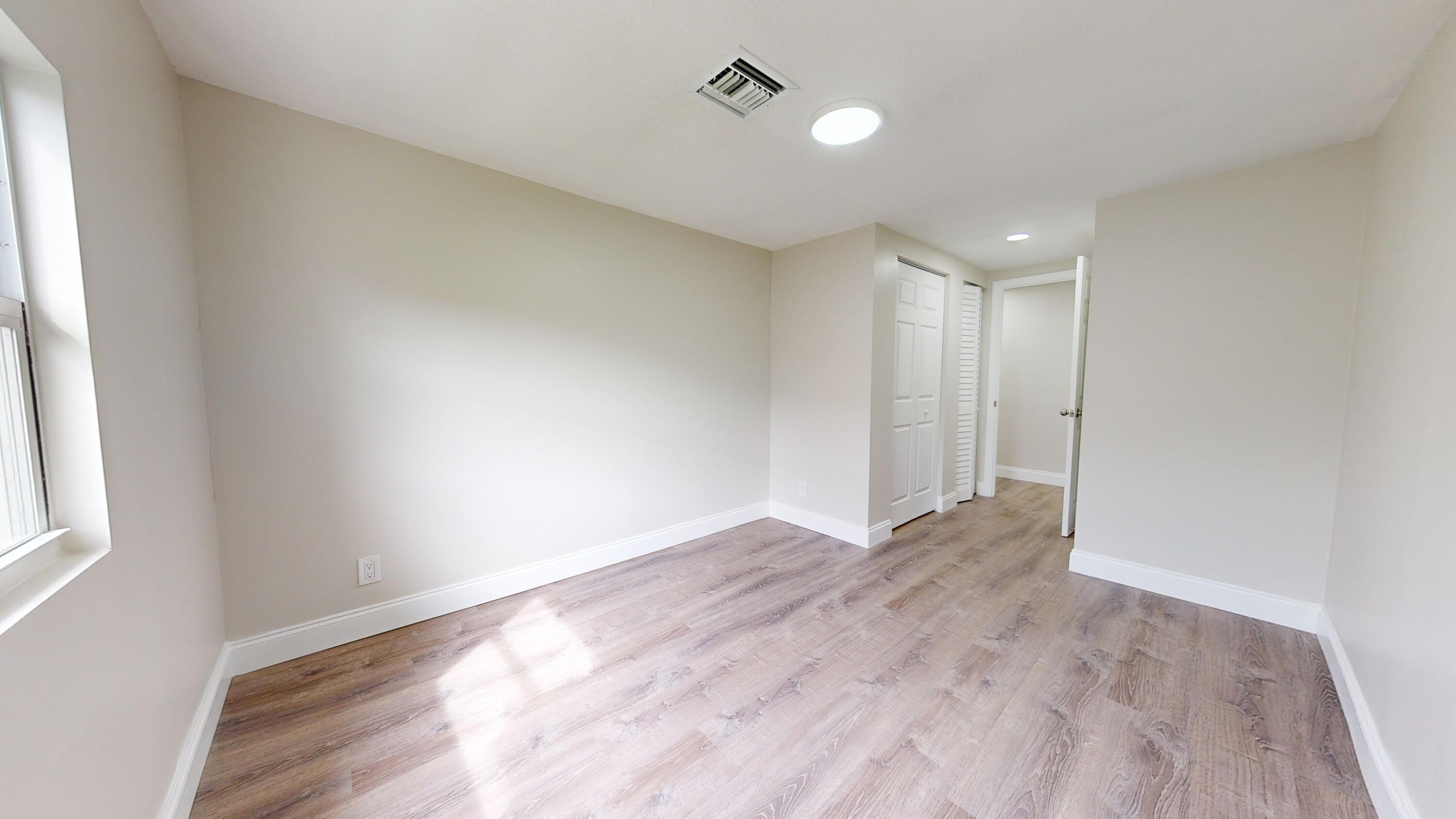 6674 4th Street Jupiter, FL 33458 - Photo 15 of 21 a view of empty room with wooden floor and fan