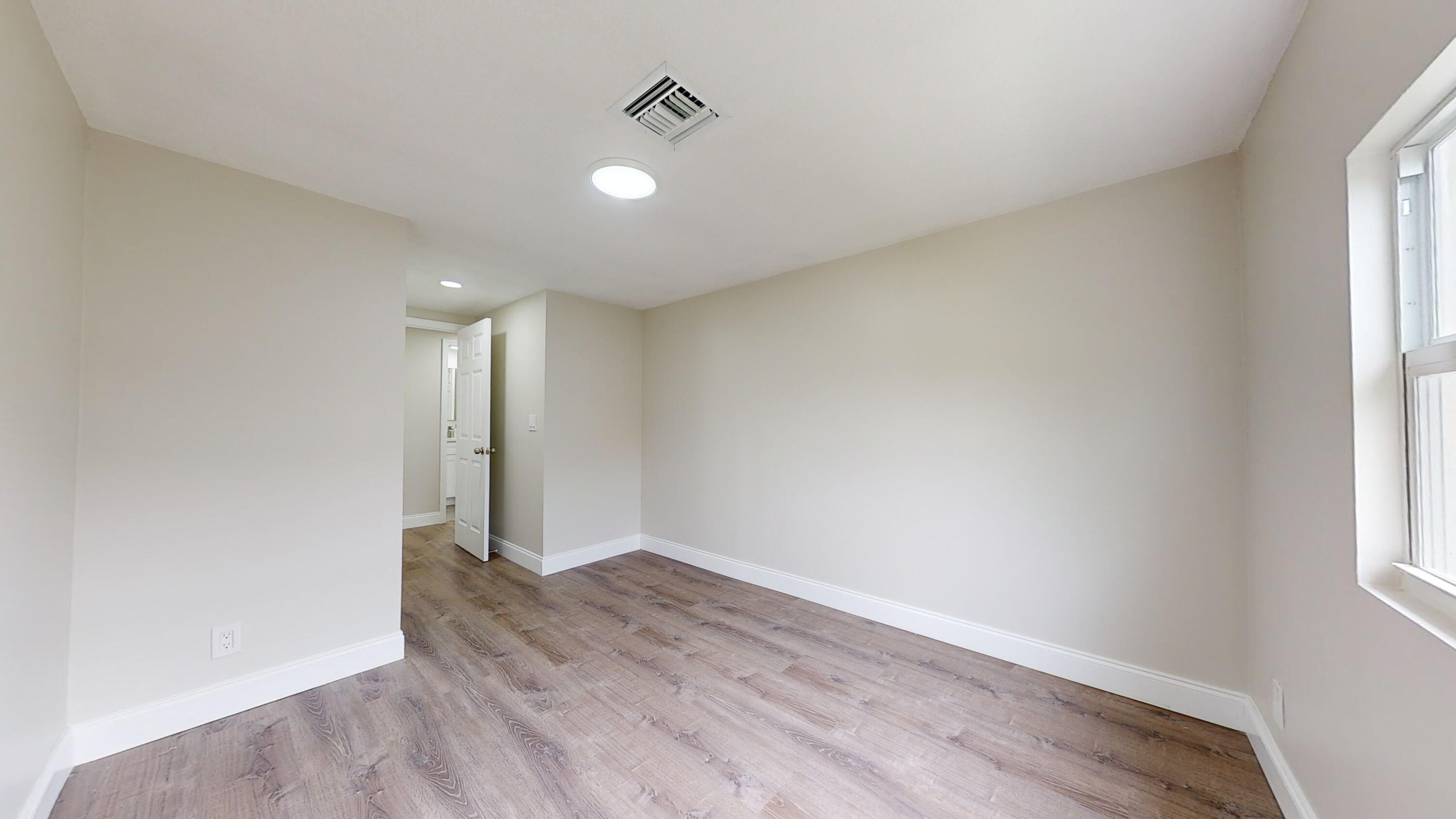 6674 4th Street Jupiter, FL 33458 - Photo 16 of 21 an empty room with wooden floor and windows