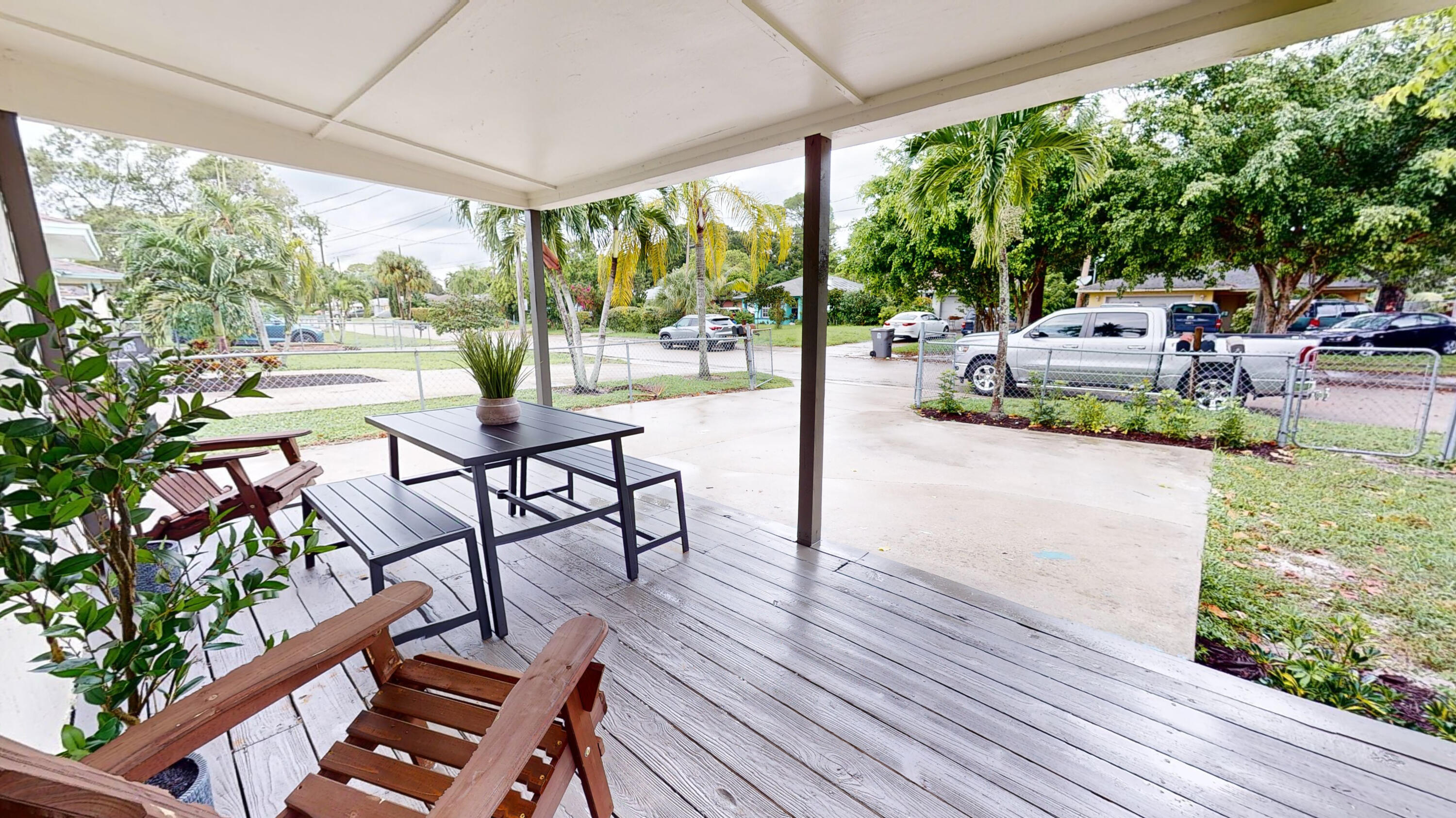 6674 4th Street Jupiter, FL 33458 - Photo 17 of 21 a view of a patio with lawn chairs floor to ceiling window with wooden floor