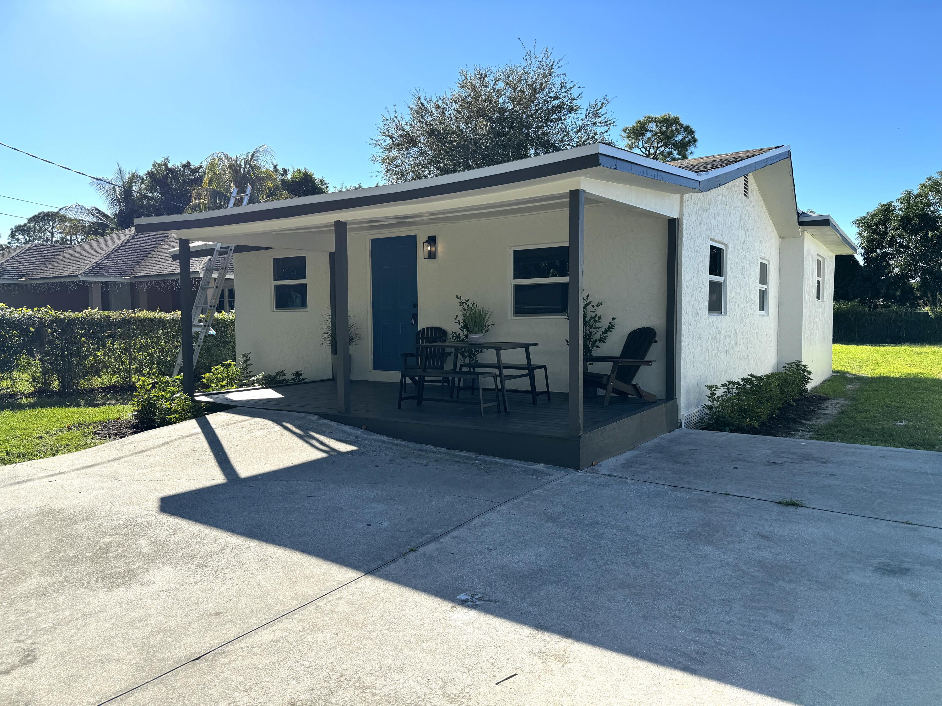 6674 4th Street Jupiter, FL 33458 - Photo 19 of 21 a view of a house with backyard porch and sitting area