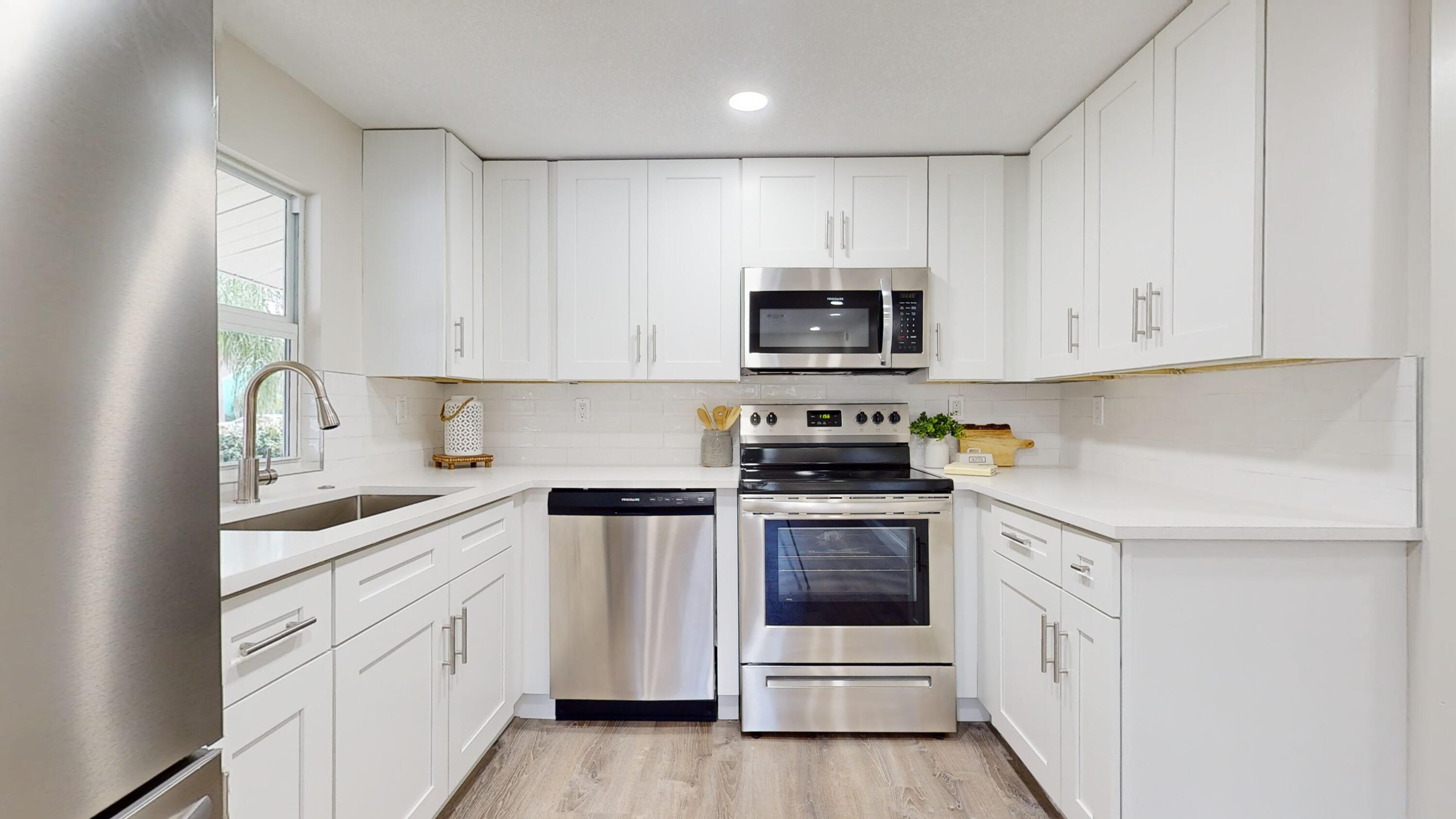 6674 4th Street Jupiter, FL 33458 - Photo 2 of 21 a kitchen with white cabinets and stainless steel appliances