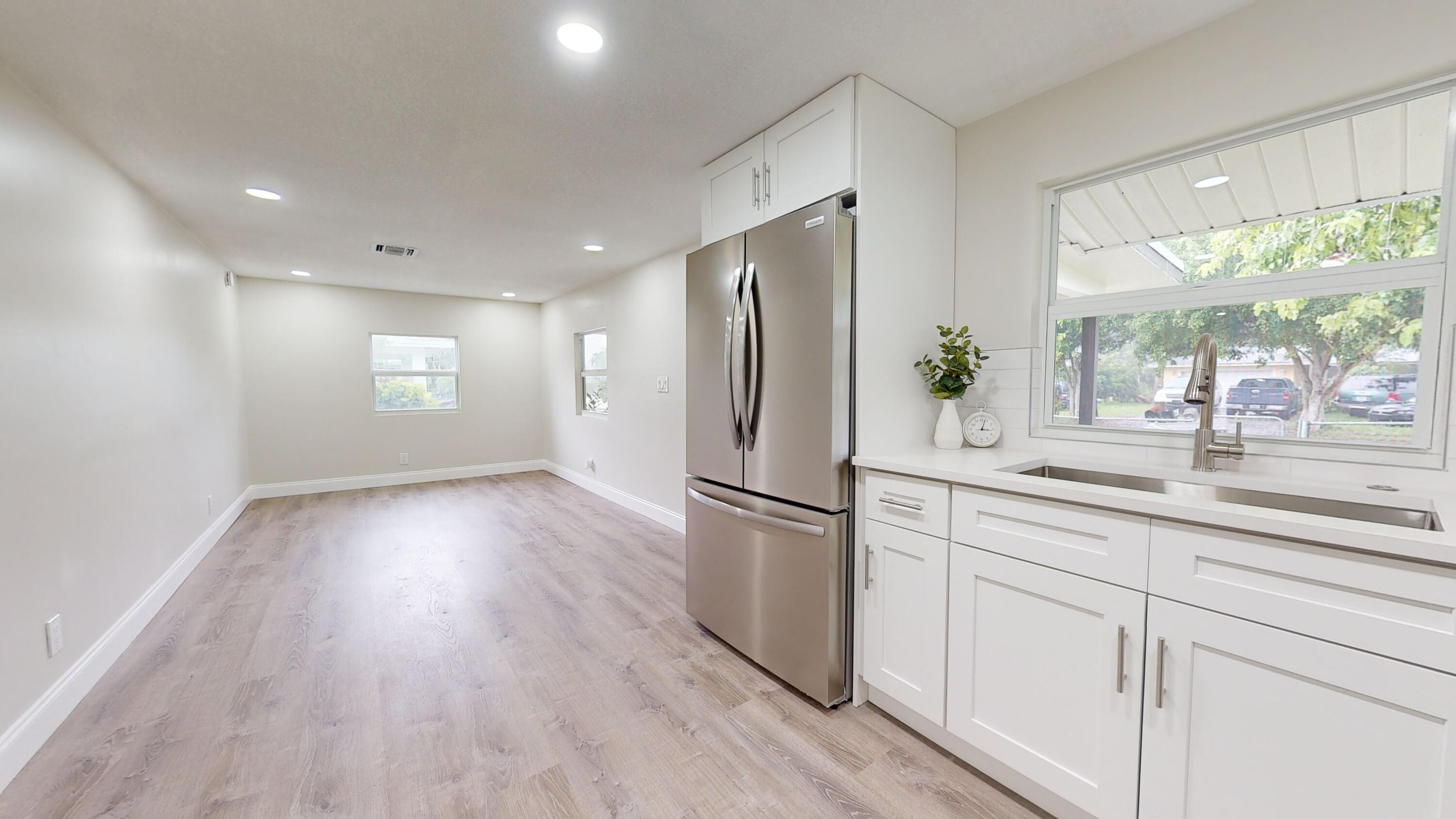 6674 4th Street Jupiter, FL 33458 - Photo 3 of 21 a kitchen with a refrigerator and wooden floors