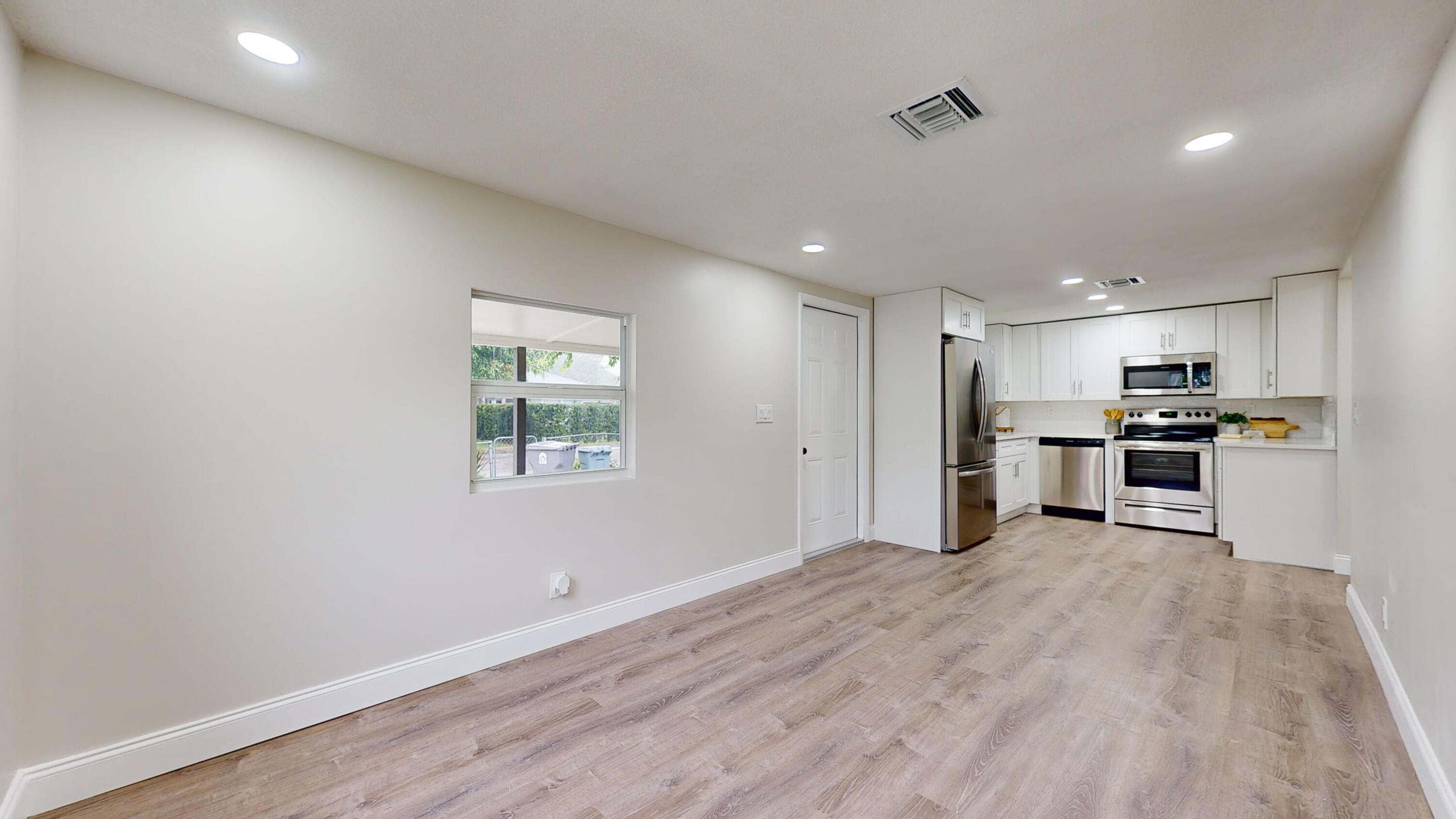 6674 4th Street Jupiter, FL 33458 - Photo 4 of 21 a view of kitchen with kitchen island a sink wooden floor and stainless steel appliances