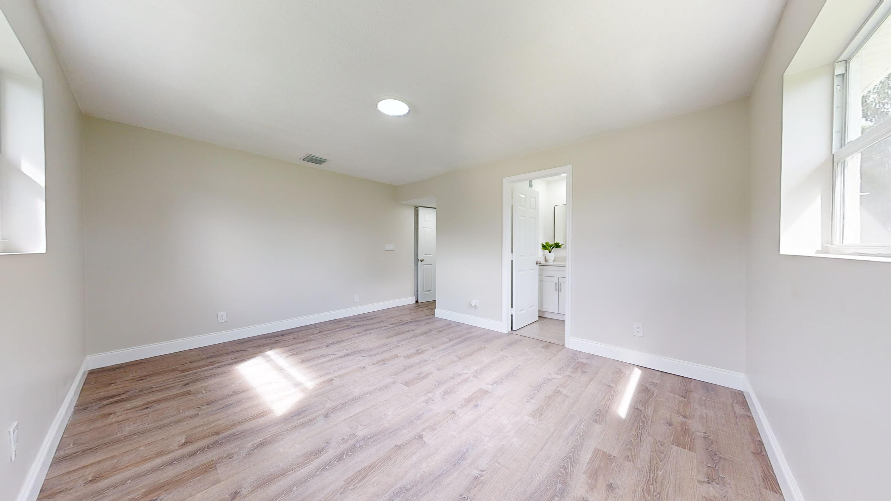 6674 4th Street Jupiter, FL 33458 - Photo 7 of 21 an empty room with wooden floor and windows
