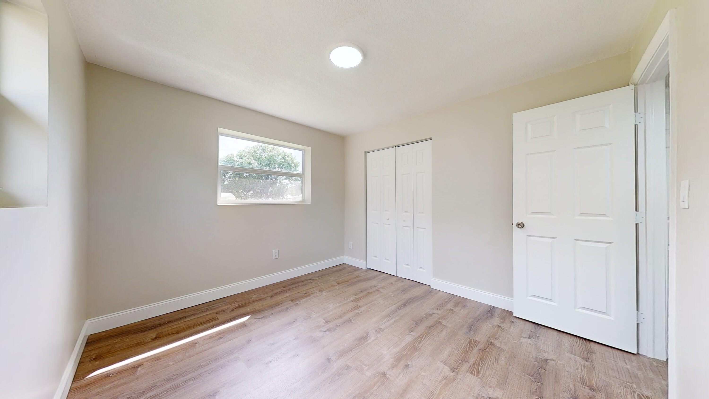 6674 4th Street Jupiter, FL 33458 - Photo 10 of 21 an empty room with wooden floor and windows