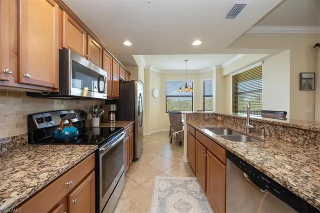 a kitchen with stainless steel appliances granite countertop a sink stove and refrigerator