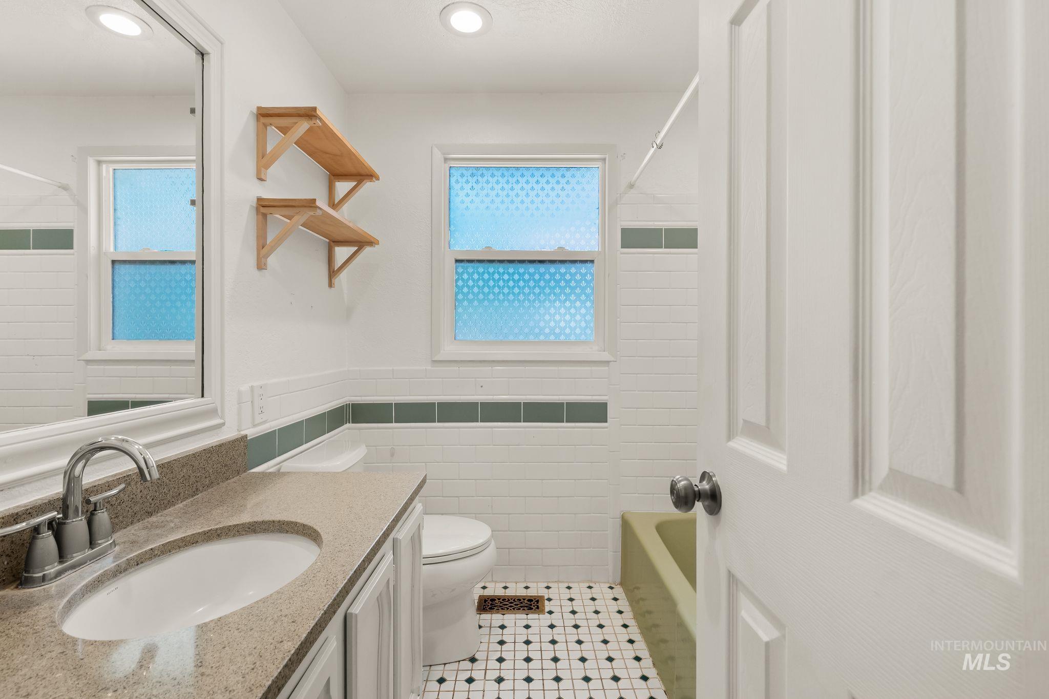 928 3rd Street Clarkston, WA 99403 - Photo 22 of 44 Bathroom featuring a single vanity with an oval undermount sink, a chrome faucet, and a light-toned countertop