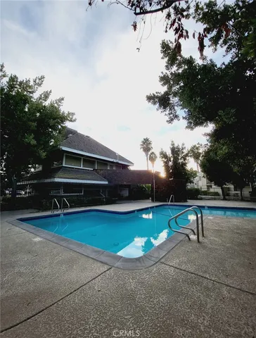 a view of a swimming pool with lawn chairs and plants