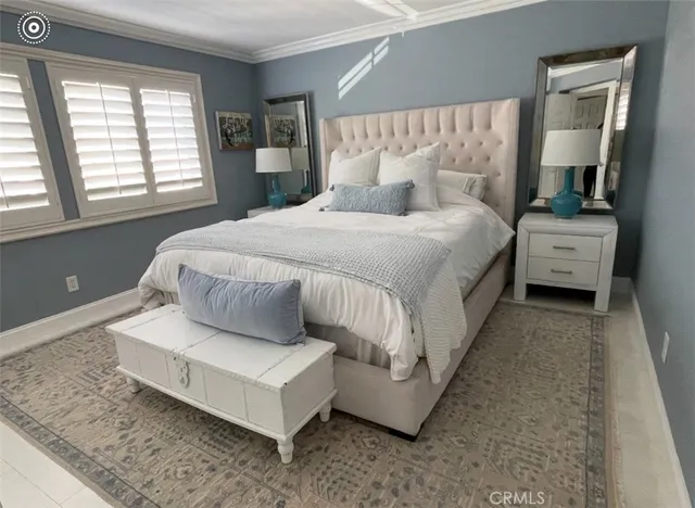 a large white bed sitting in a bedroom next to a window