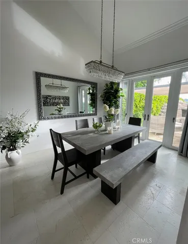 a dining room with furniture a chandelier and window