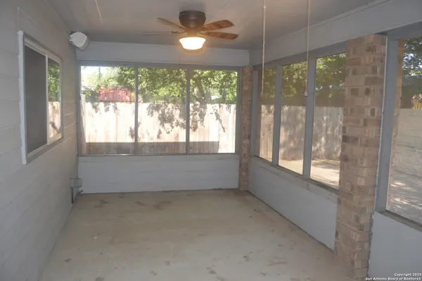 a view of empty room with window and bathroom