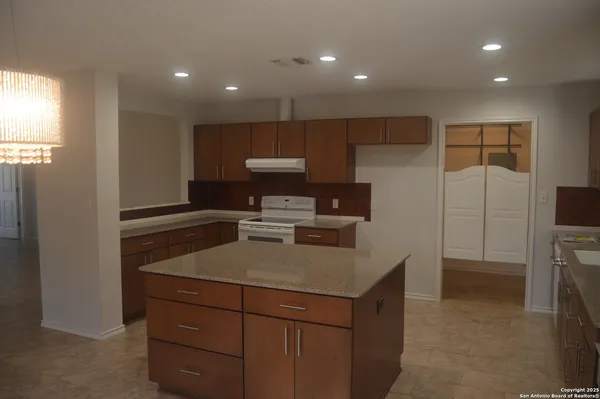 a kitchen that has a sink a stove and a refrigerator