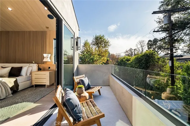 a bedroom with bed and large windows