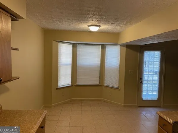 a view of an empty room with window and a bathroom