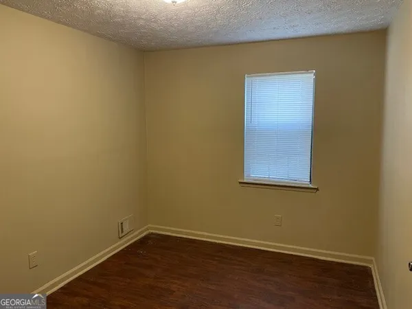 a view of a small space with wooden floor and a window