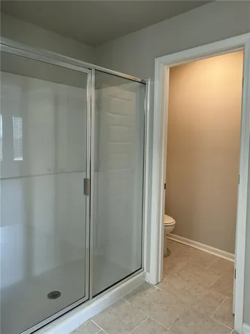 a bathroom with a granite countertop toilet and a shower
