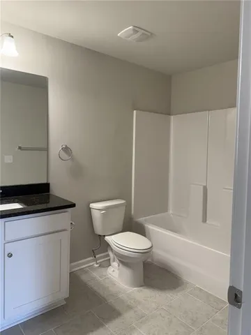 a bathroom with a granite countertop sink a toilet a mirror and shower