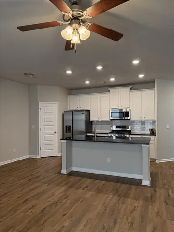a kitchen with stainless steel appliances a stove top oven a refrigerator and a sink