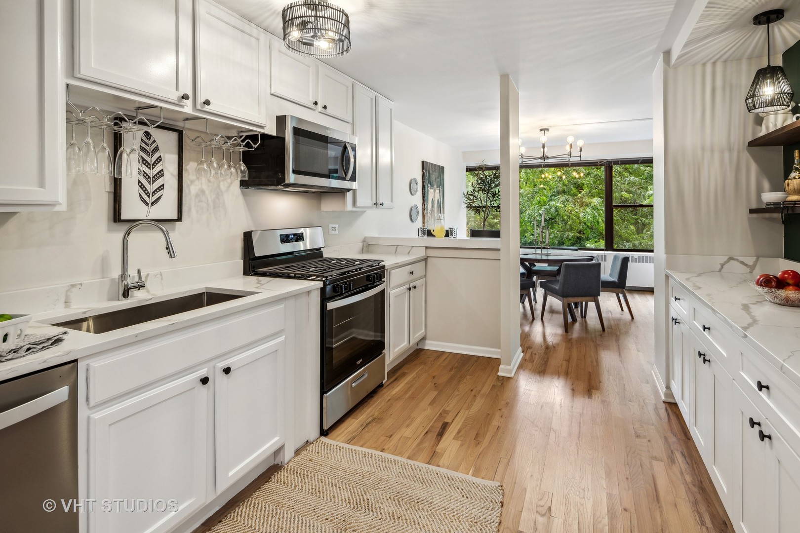 1540 North State Parkway, Unit 3D Chicago, IL 60610 - Photo 6 of 15 a kitchen with stainless steel appliances granite countertop a stove a sink dishwasher and a microwave oven with wooden floor