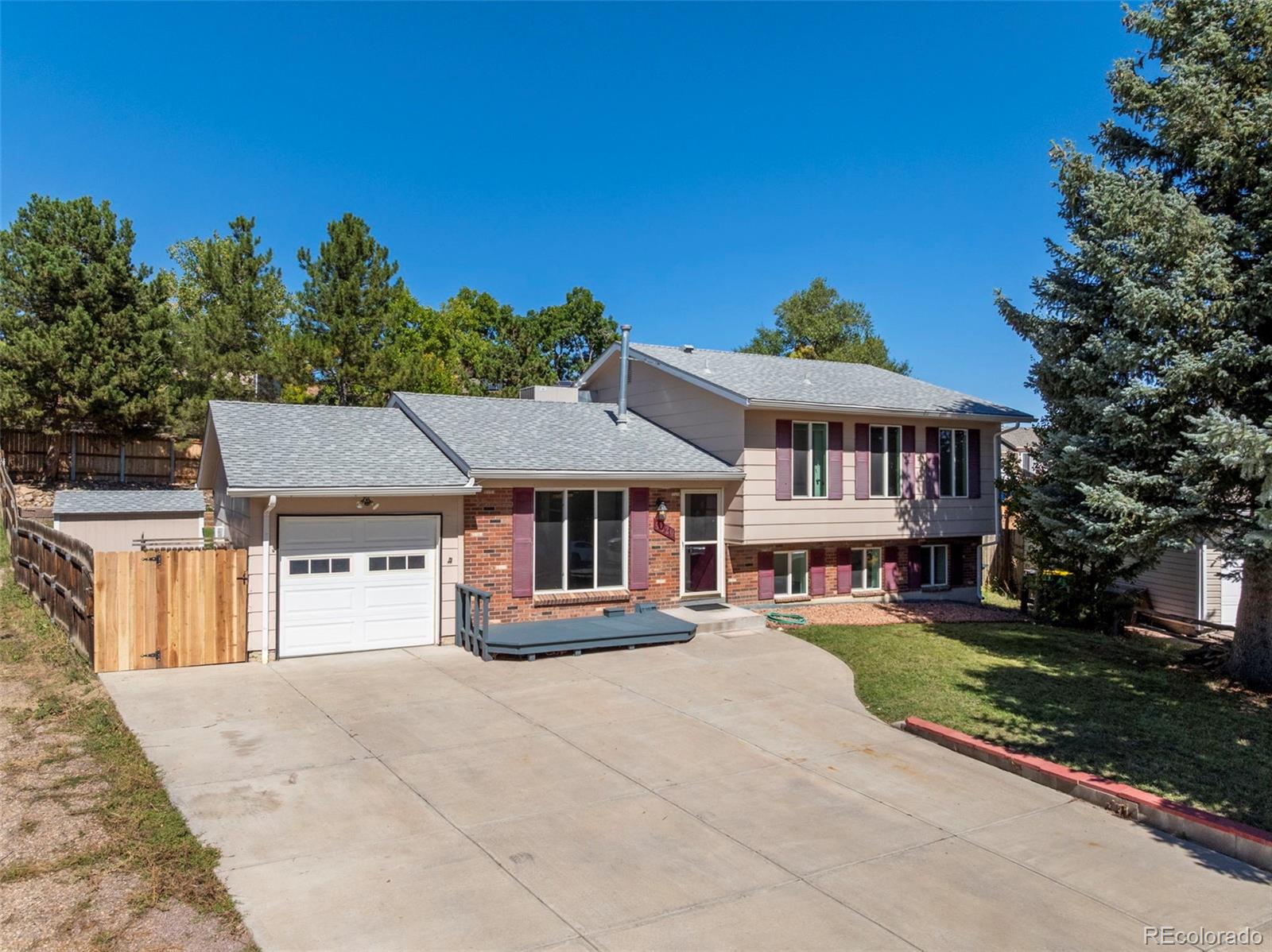 4420 South Vivian Way Morrison, CO 80465 - Photo 1 of 50 a front view of a house with a yard