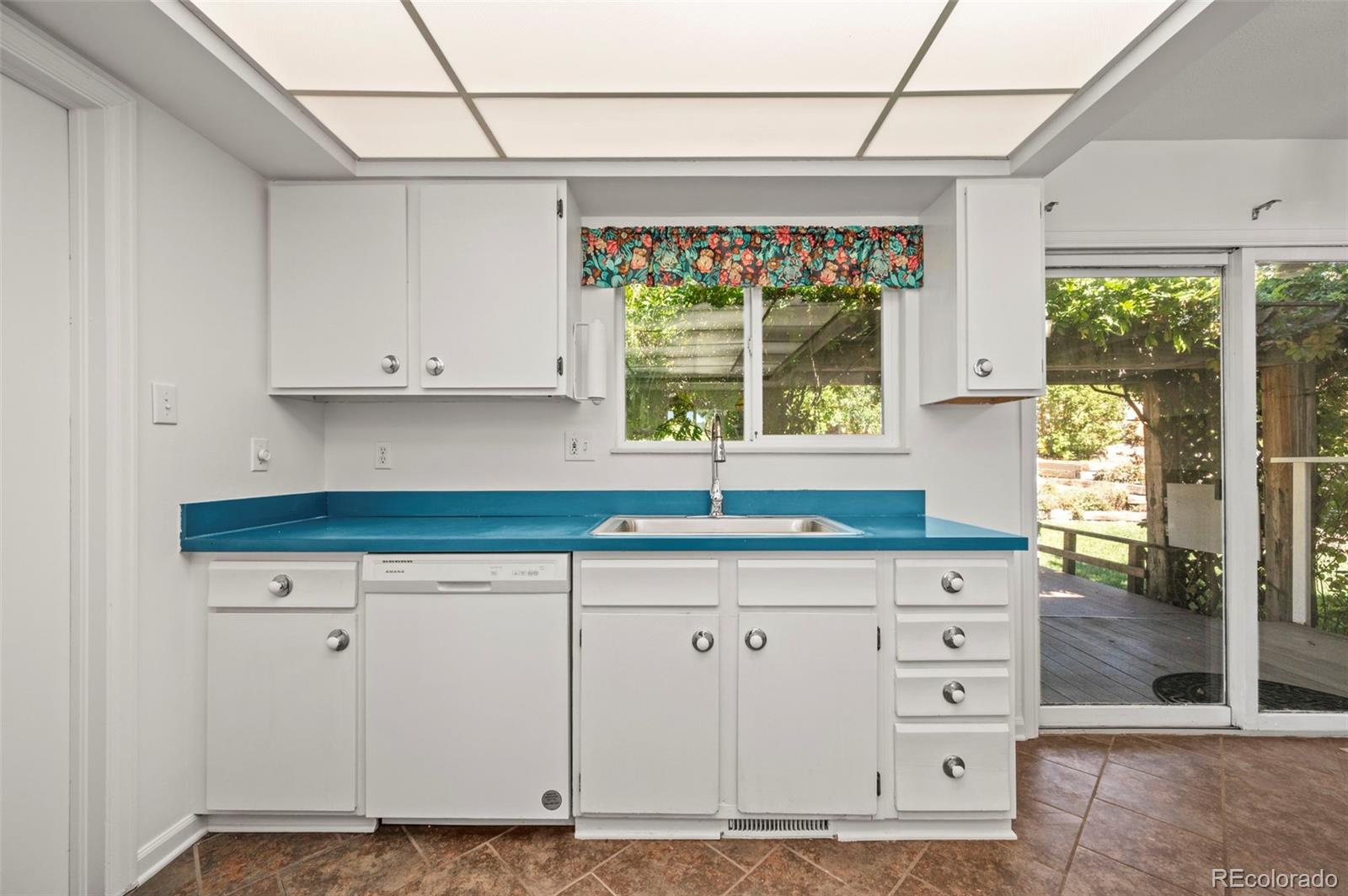4420 South Vivian Way Morrison, CO 80465 - Photo 12 of 50 a kitchen with granite countertop a sink window and cabinets
